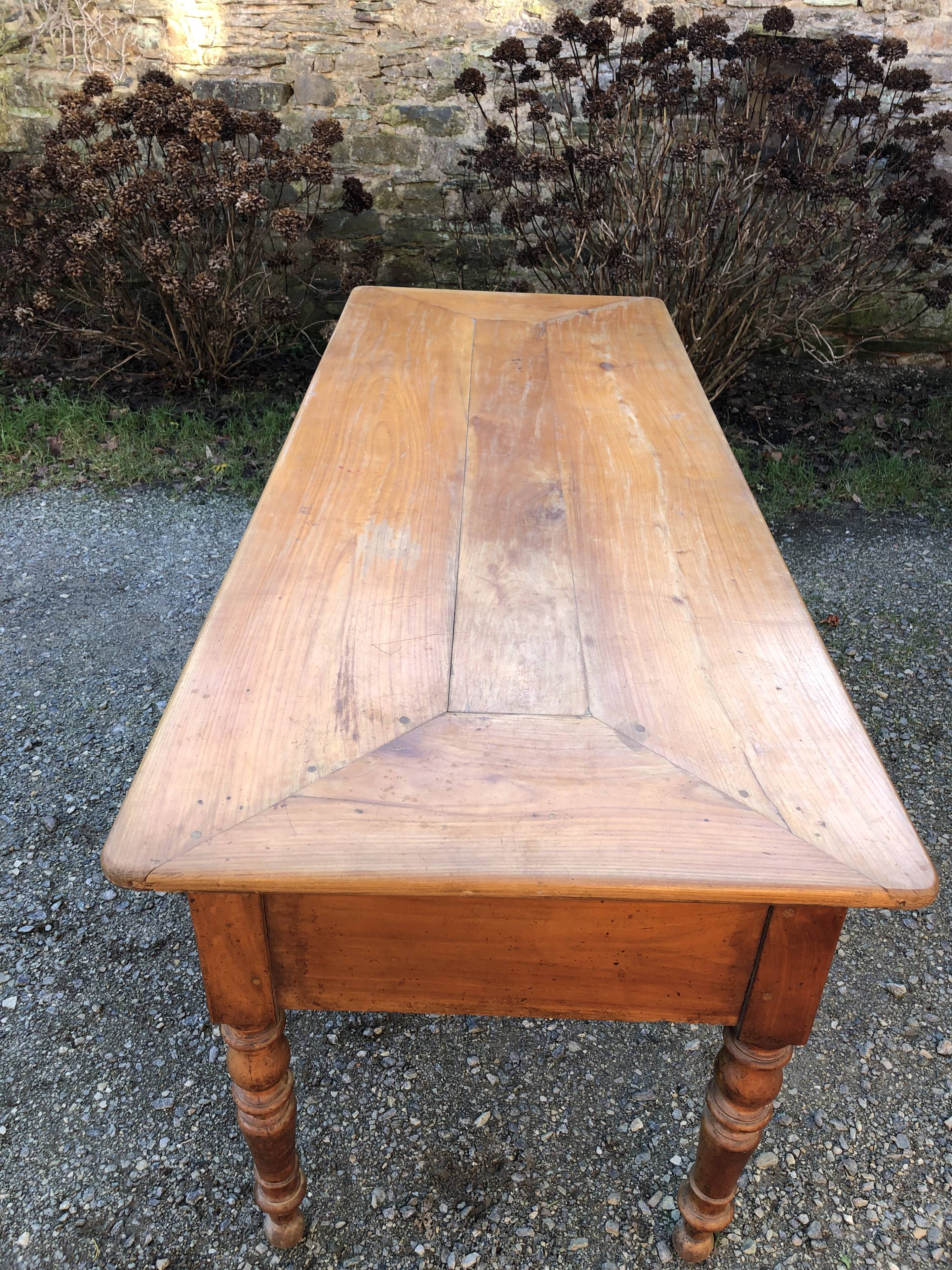 Antique cherry farmhouse table with turned legs and 2 drawers.
