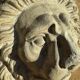 Off-white plaster lion head relief on natural wood panel — Walter De Buck, classical decorative sculpture