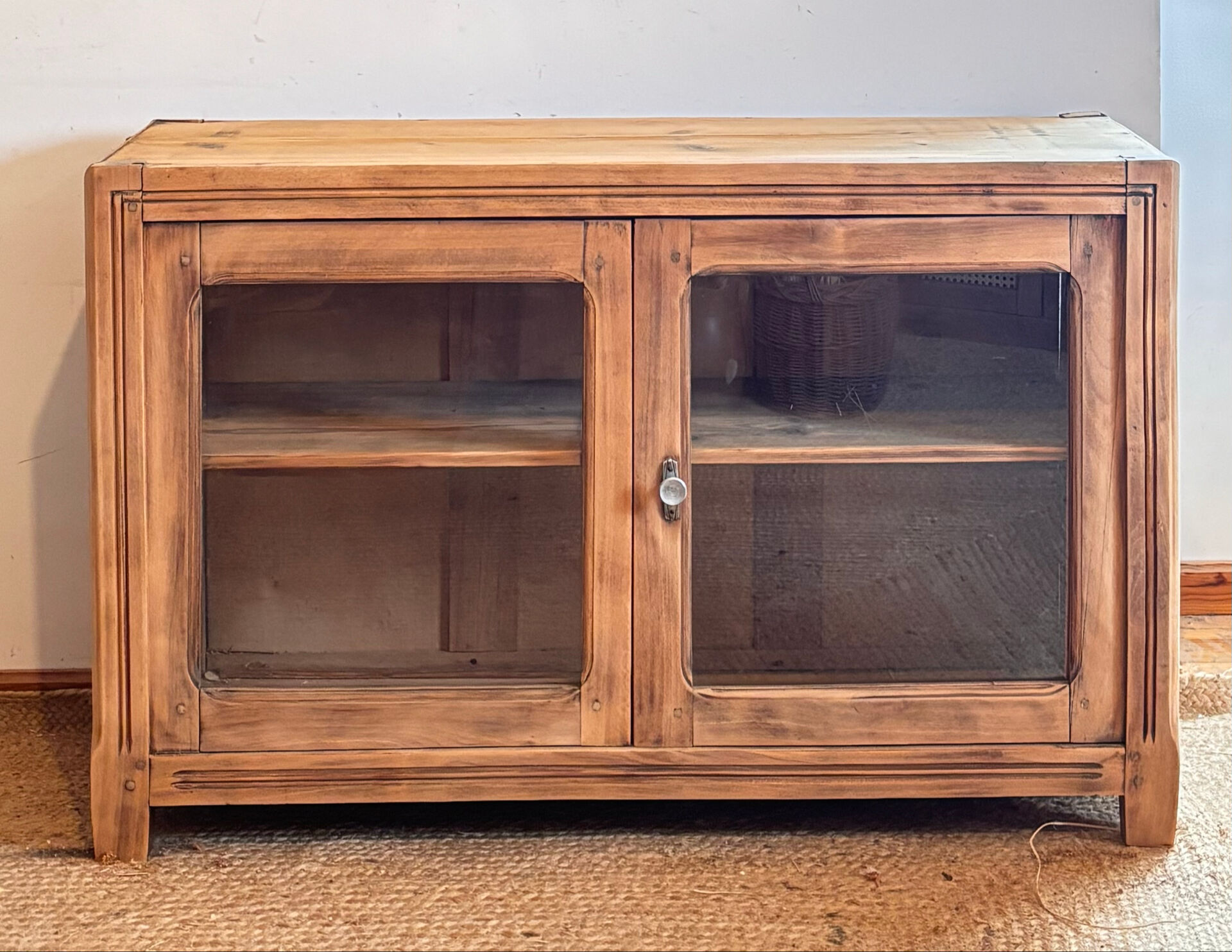 Old wooden buffet with a glass front in raw wood