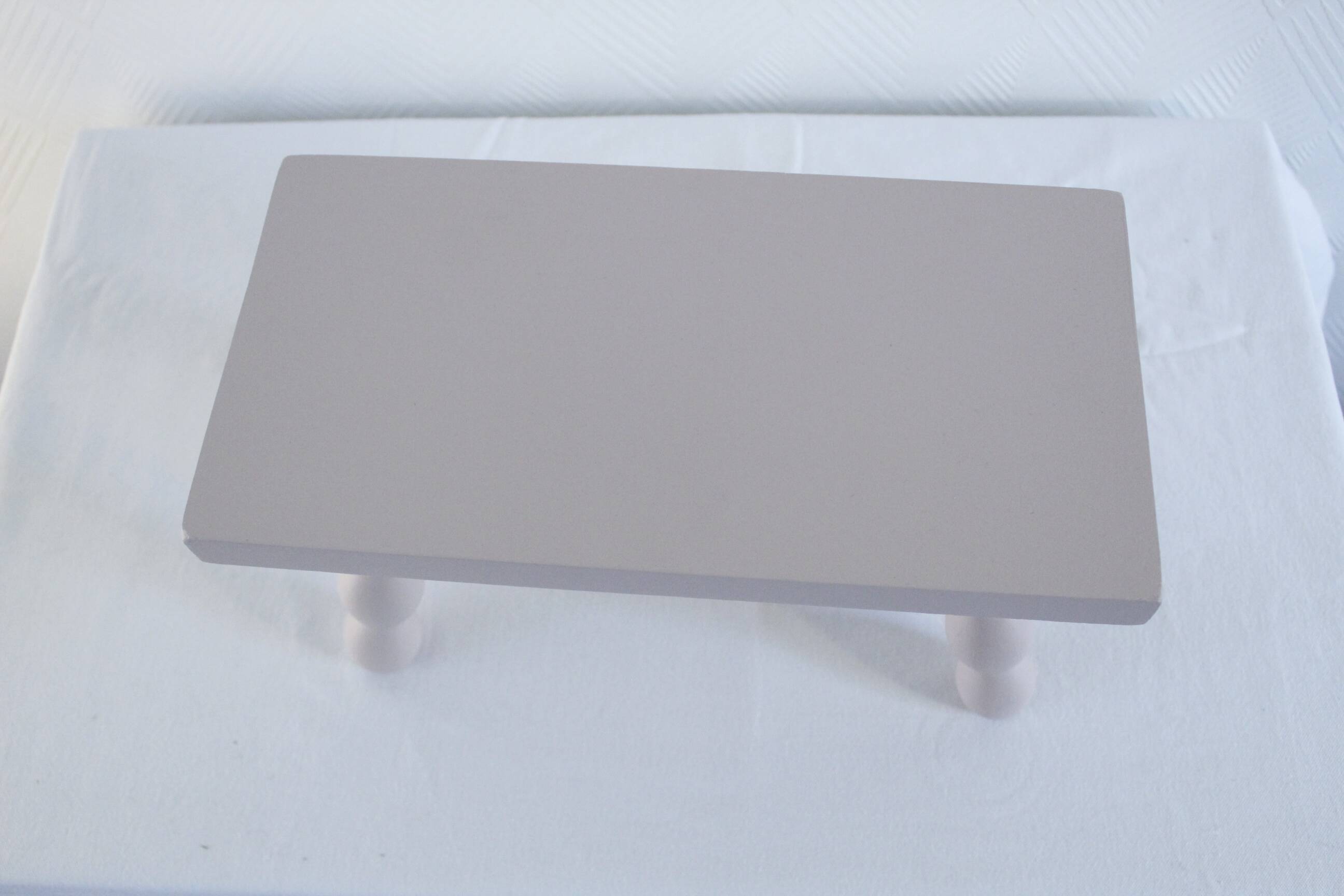 Small vintage wooden bench renovated in pinkish beige