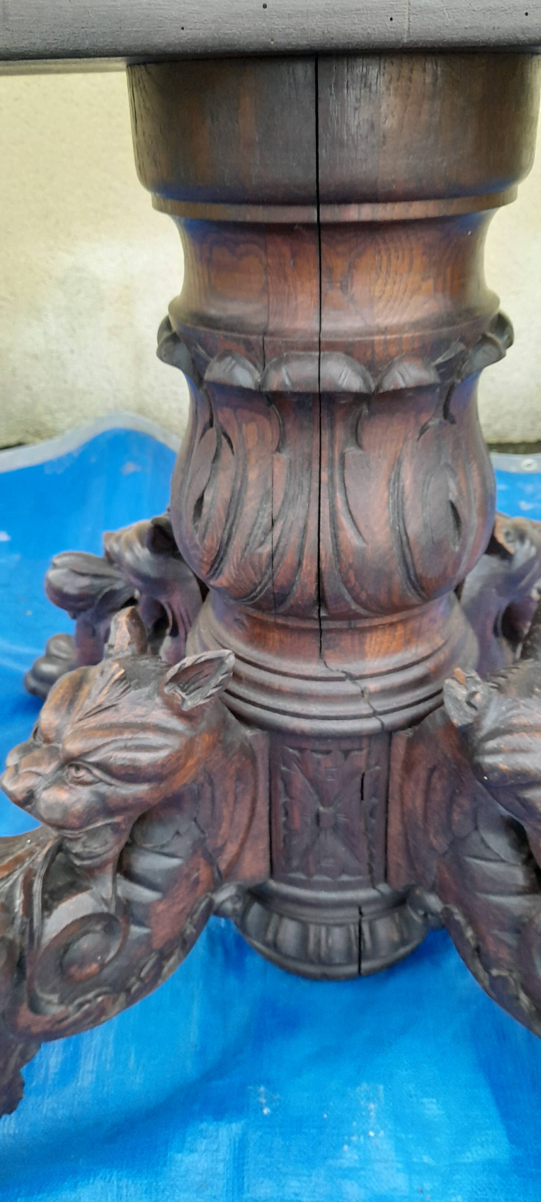 Round table in molded and carved oak with quill decoration, central shaft with 4 runners