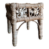 Tabouret en osier vintage, petit repose-pieds en rotin tissé et support de plante rustique.