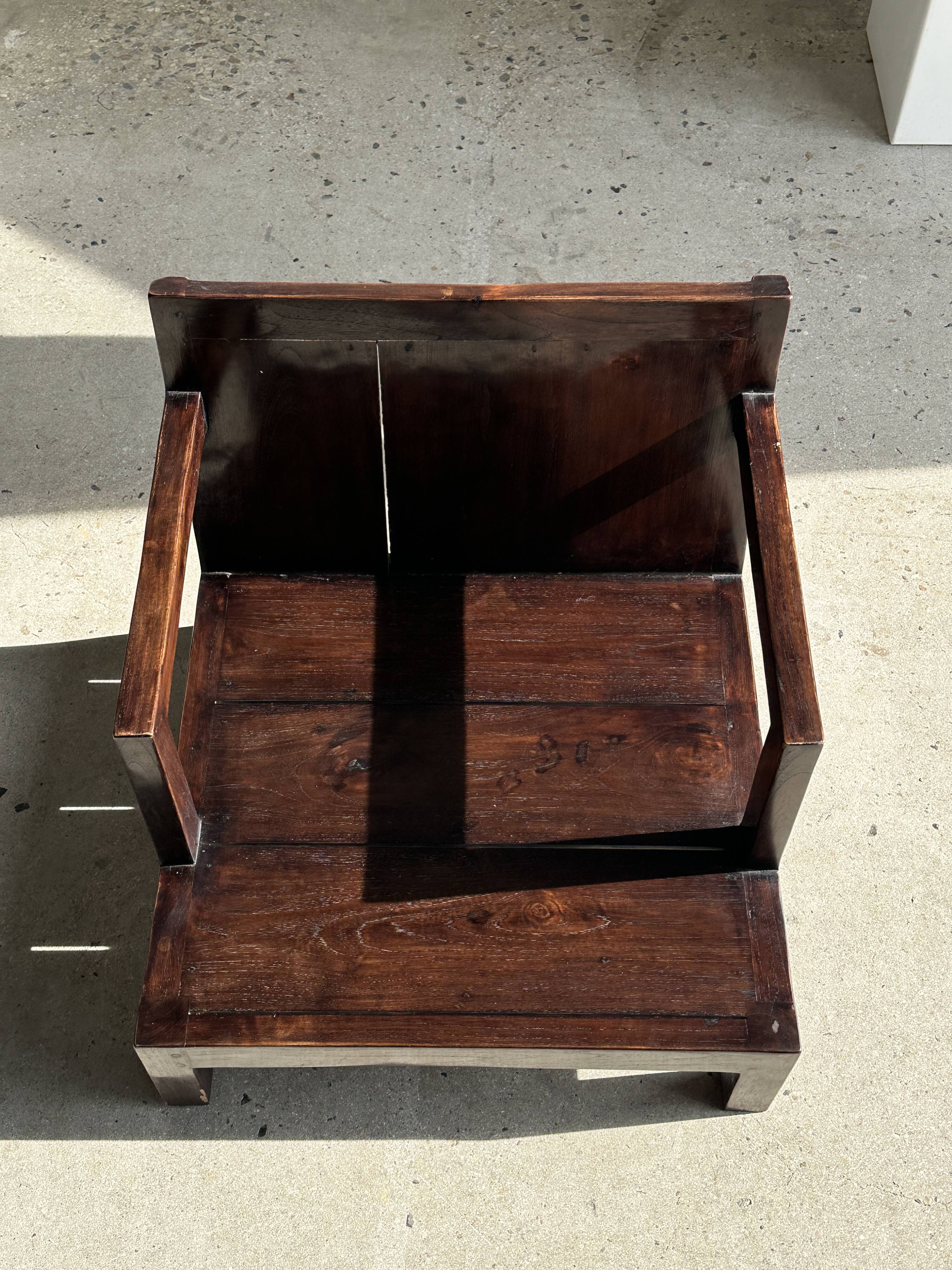 Small low armchair in varnished brown wood
