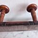 Wall-mounted coat rack with 8 turned wooden hooks in faux bamboo style.