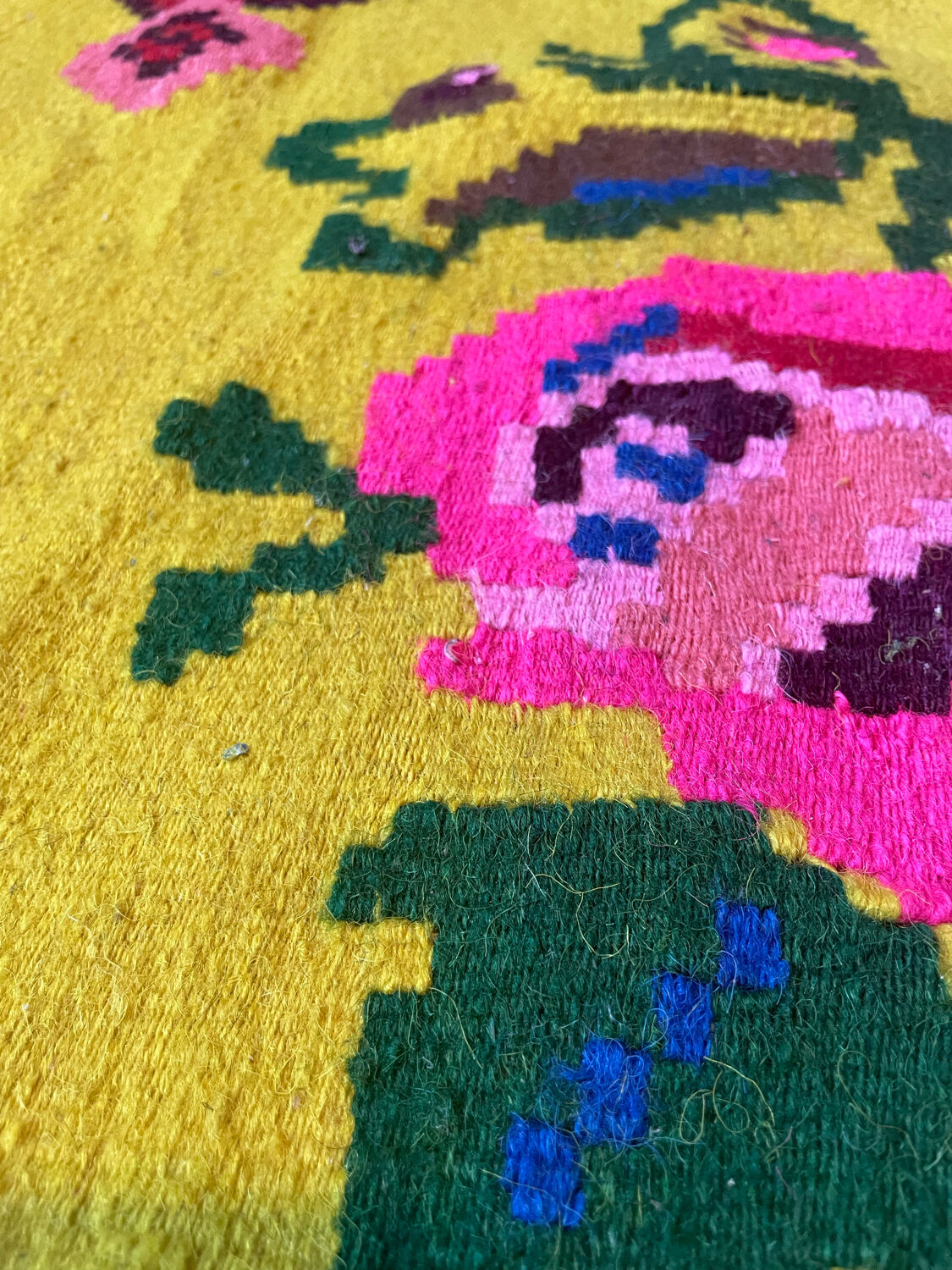 Vintage wool rug with pink flowers on green and yellow background made by hand in Transylvania