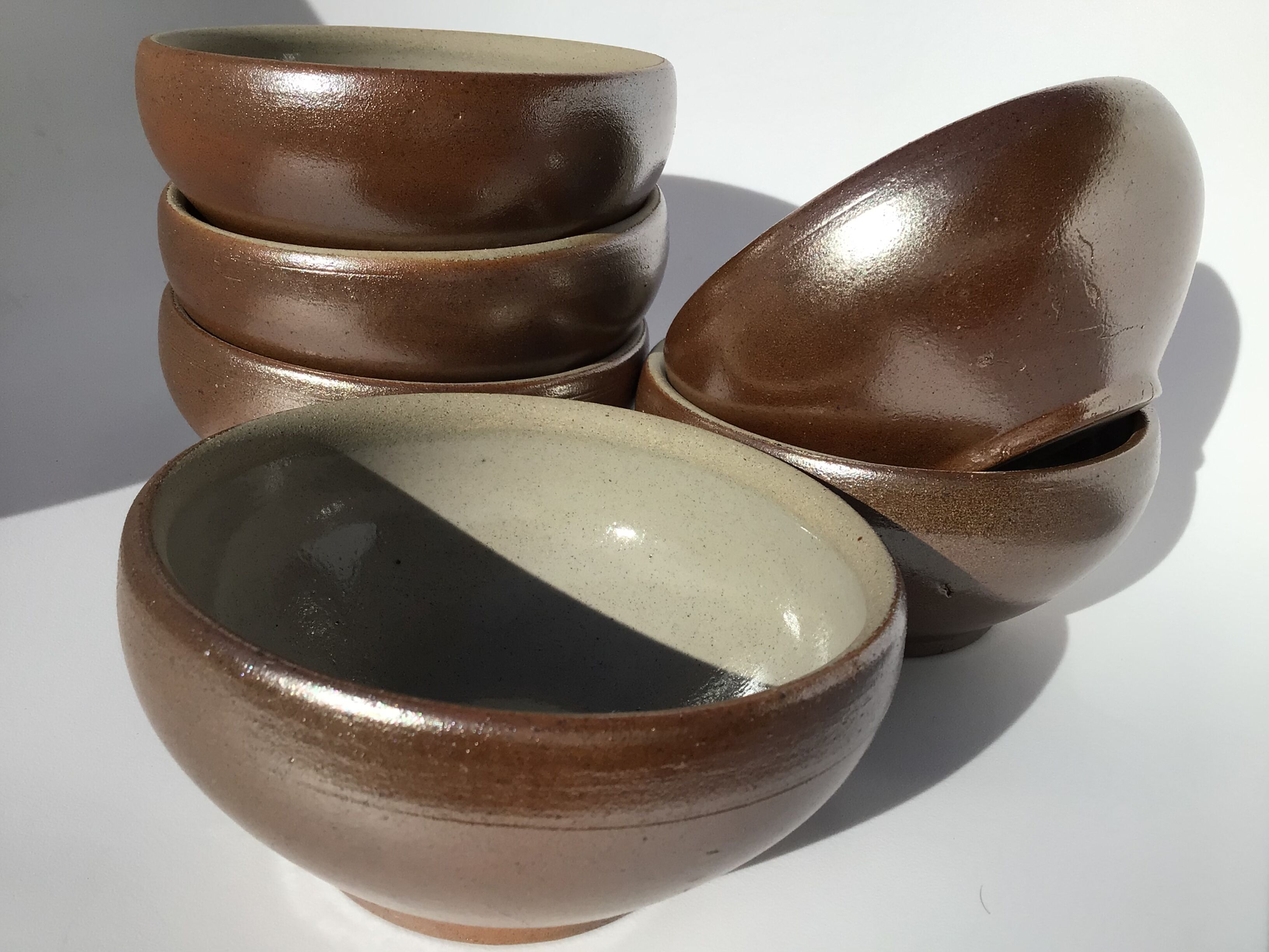 6 iridescent brown sandstone bowls inside grey