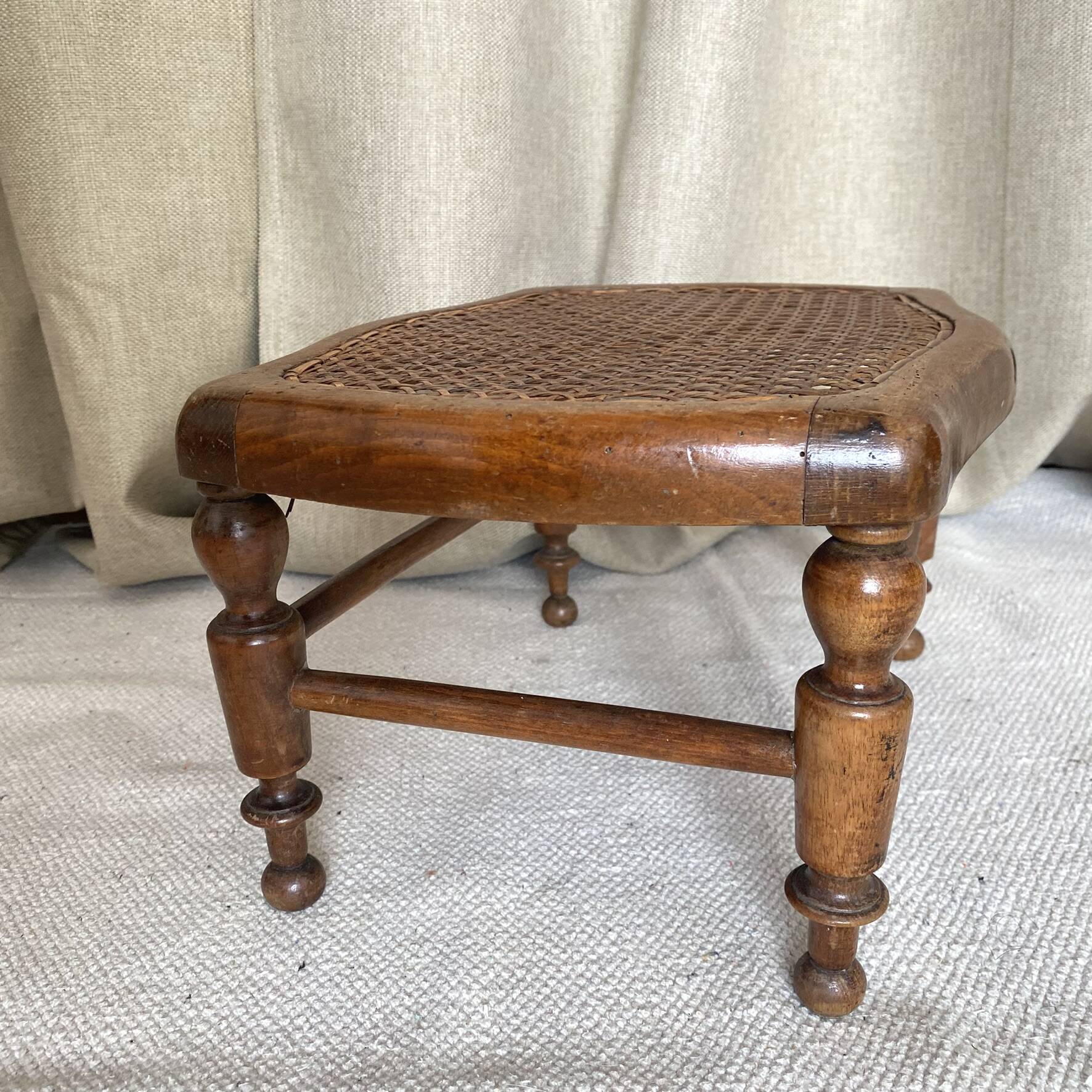 Low wooden stool with caning, footrest.