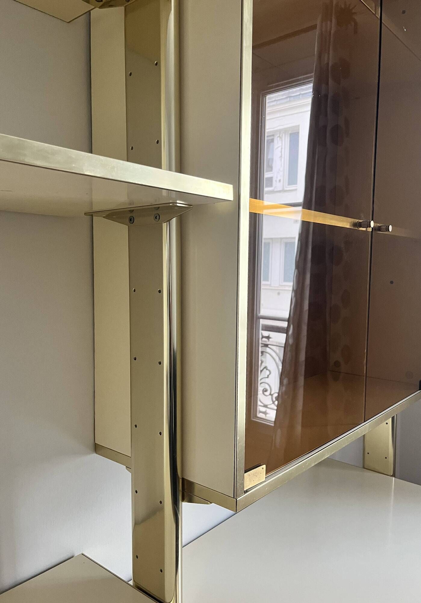 Wall-mounted and modular bookcase in lacquered brass, mirrors and smoked glass by Mahey, Design 1970