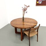 Modernist round table in solid elm, crossed legs.