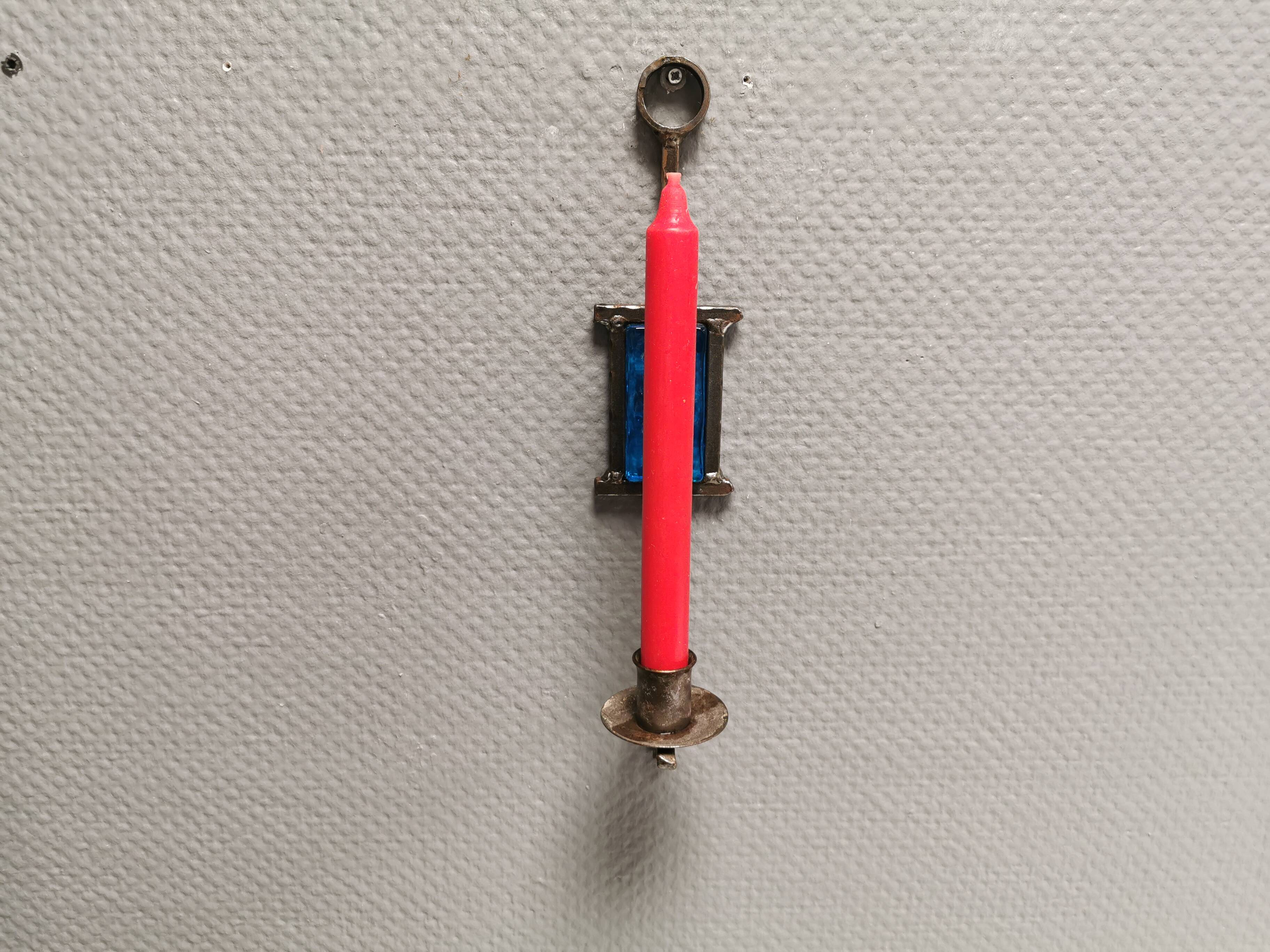 Wall-mounted candle holder in cast iron and hard pressed blue glass.