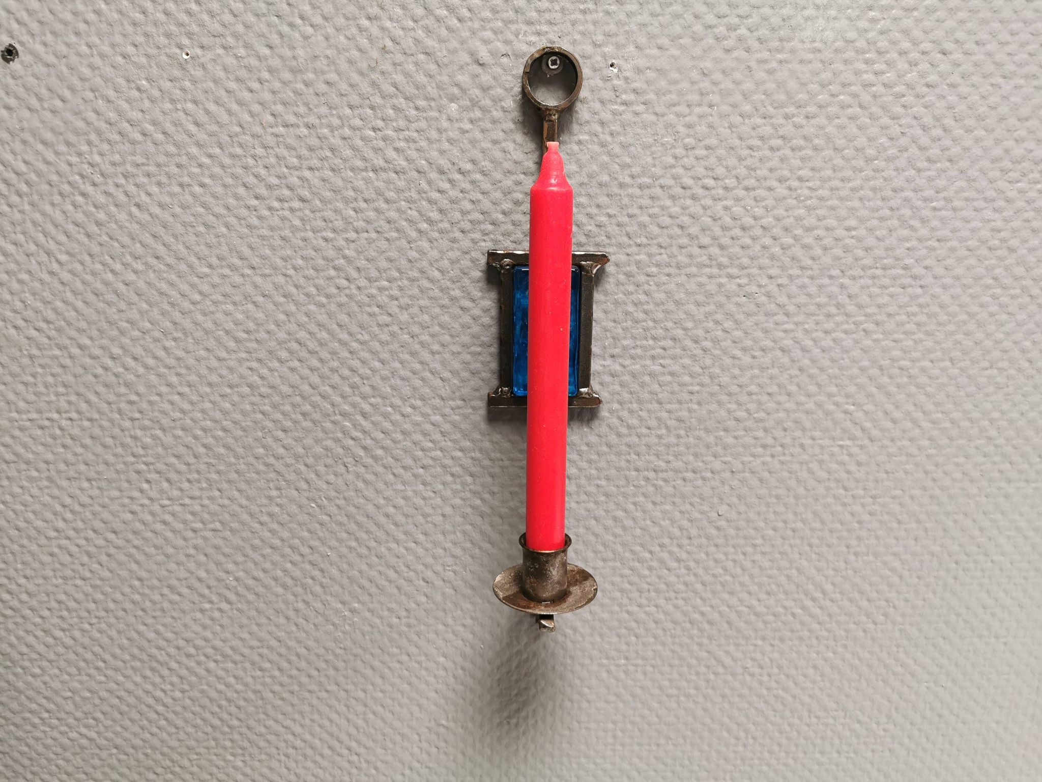 Wall-mounted candle holder in cast iron and hard pressed blue glass.