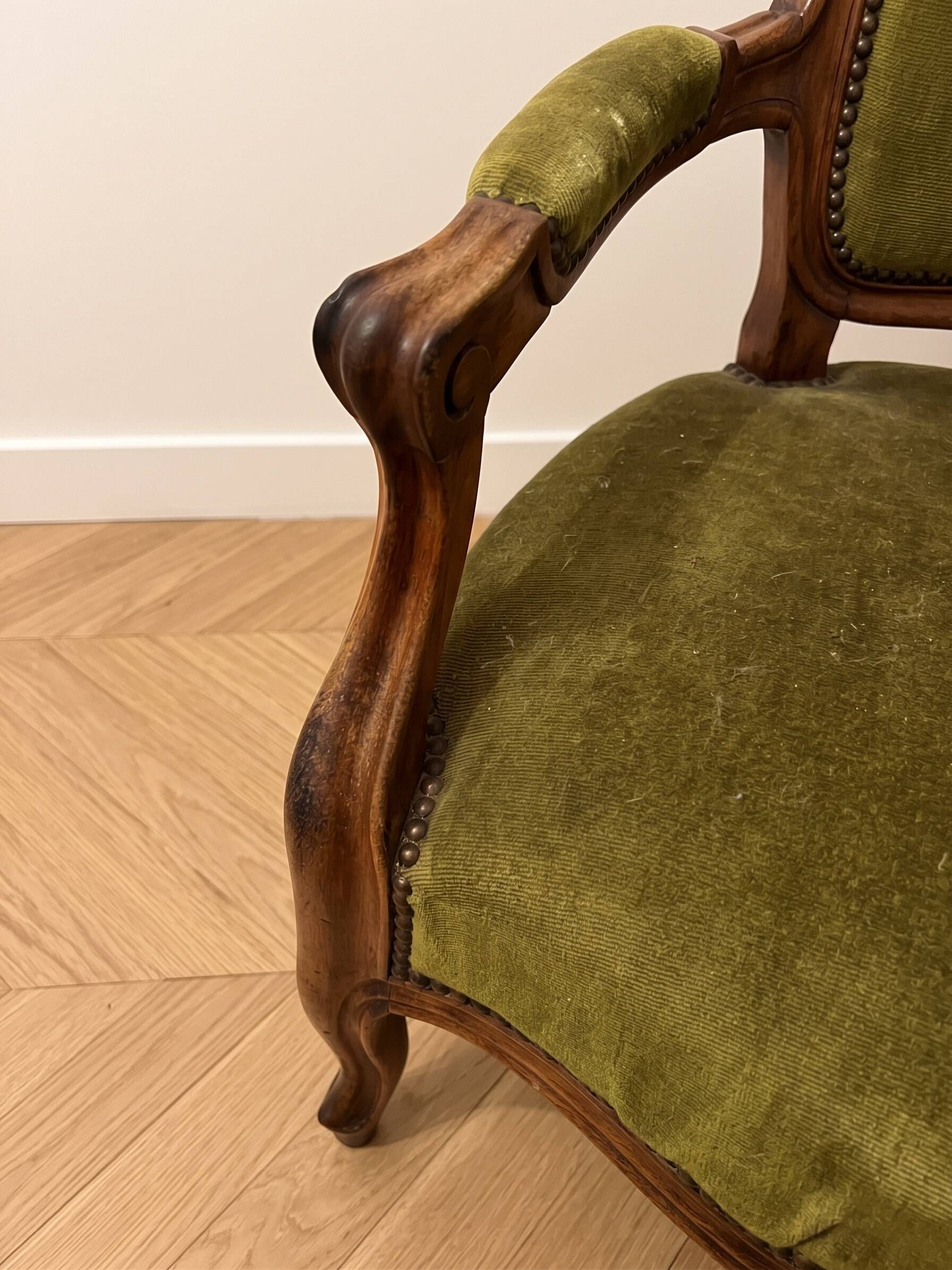 Antique armchair in olive green velvet and carved wood.