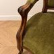 Antique armchair in olive green velvet and carved wood.