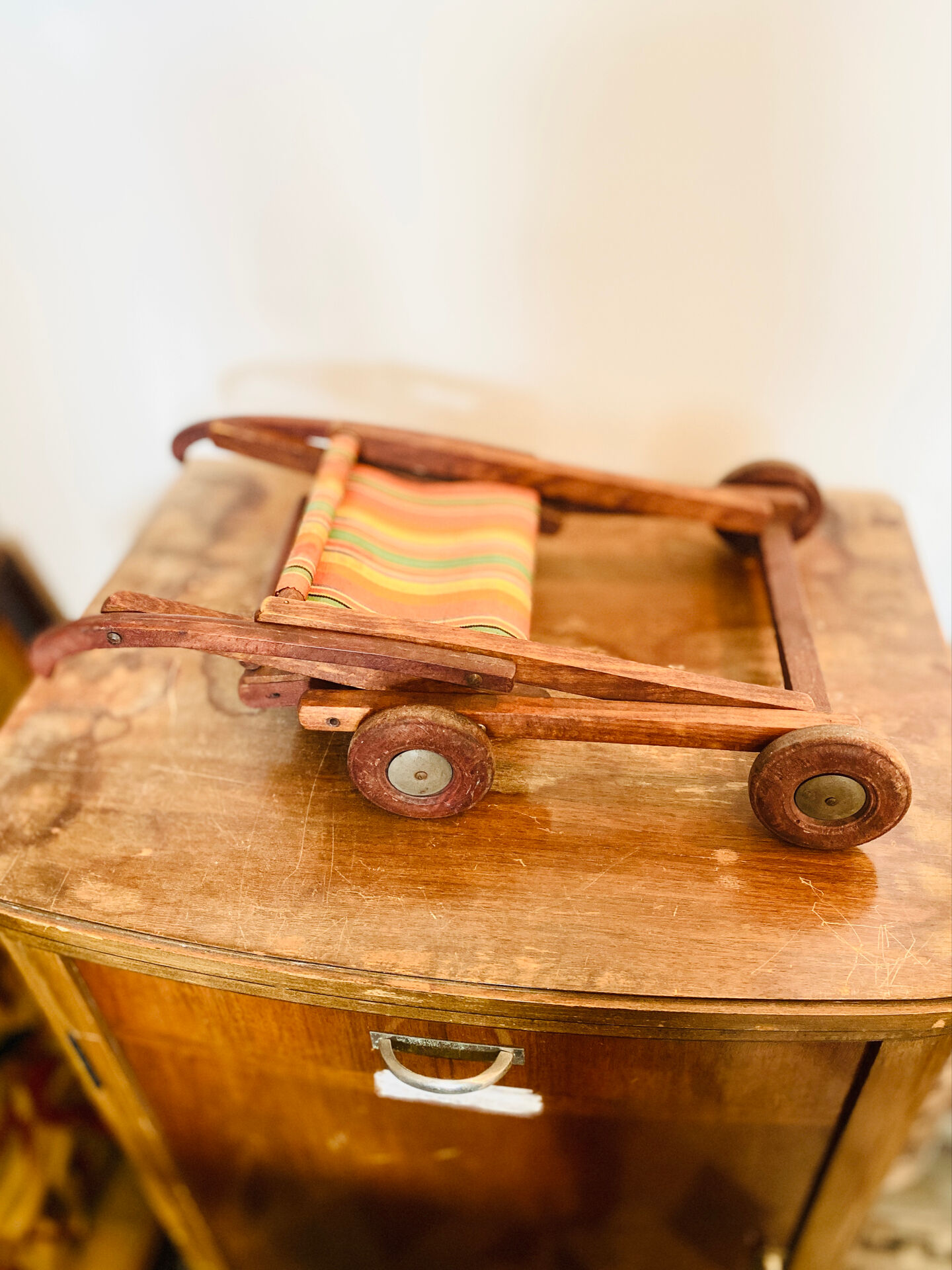 Vintage wooden folding doll's deckchair on wheels