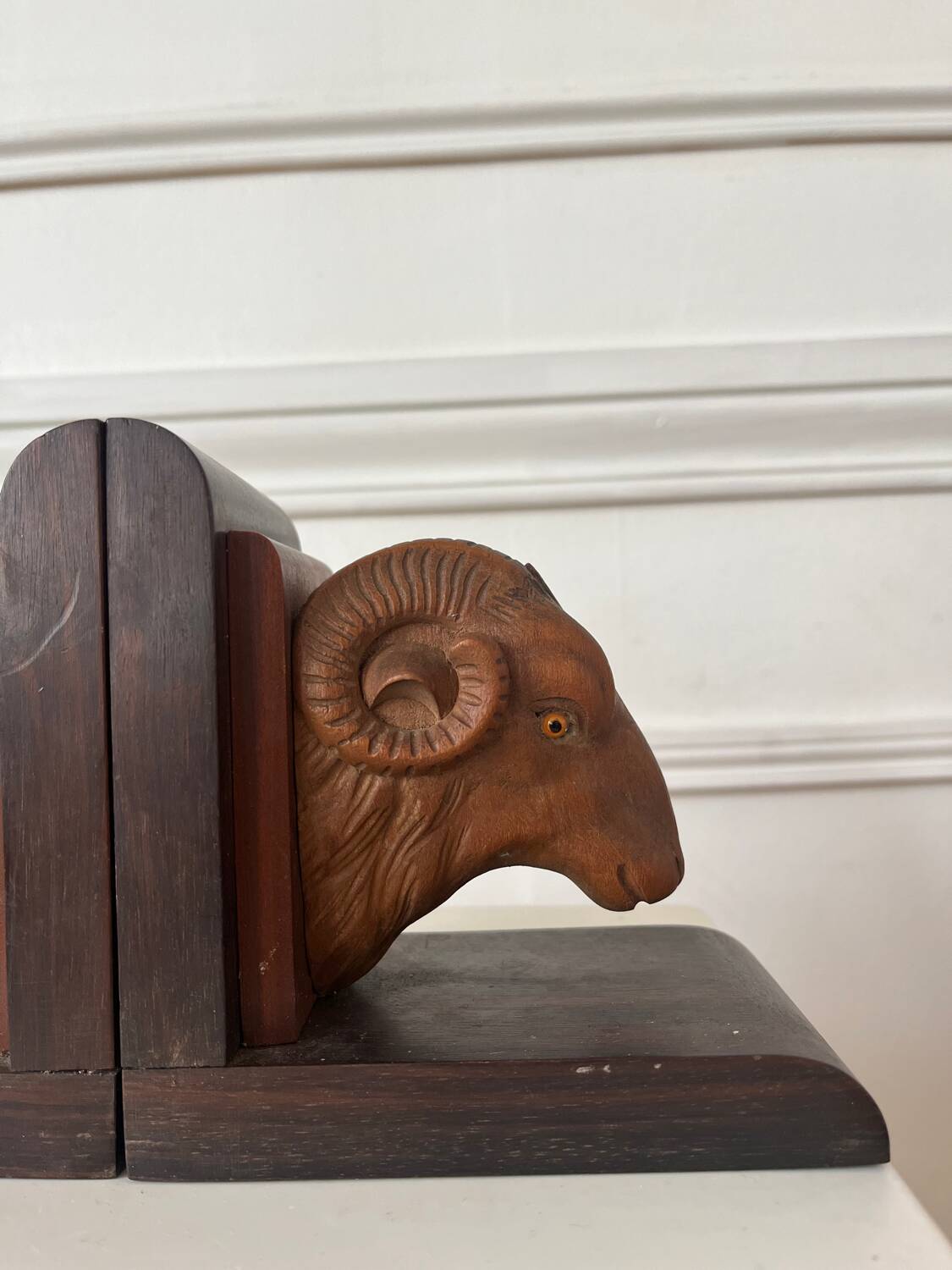 Pair of carved wooden bookends in the shape of ram's heads.