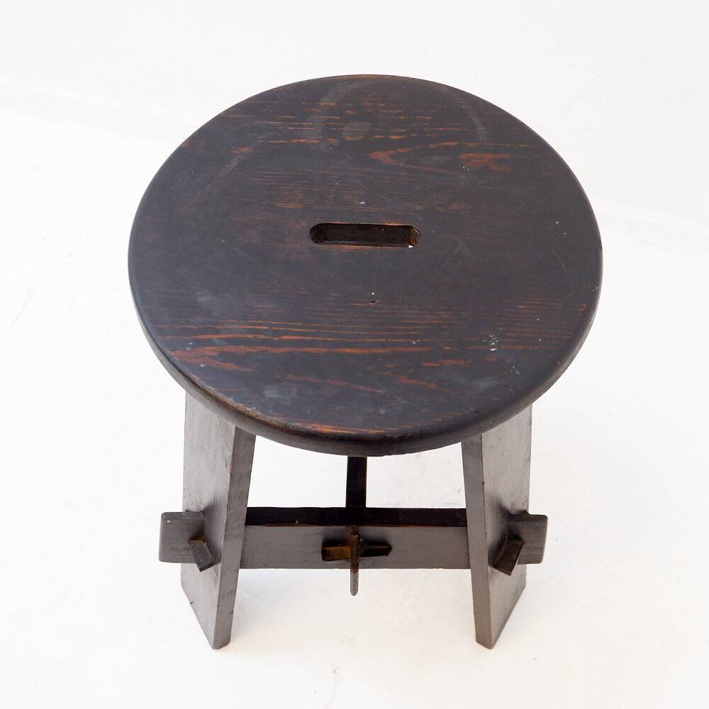 Vintage black-stained wooden tripod stool with mortise joints.