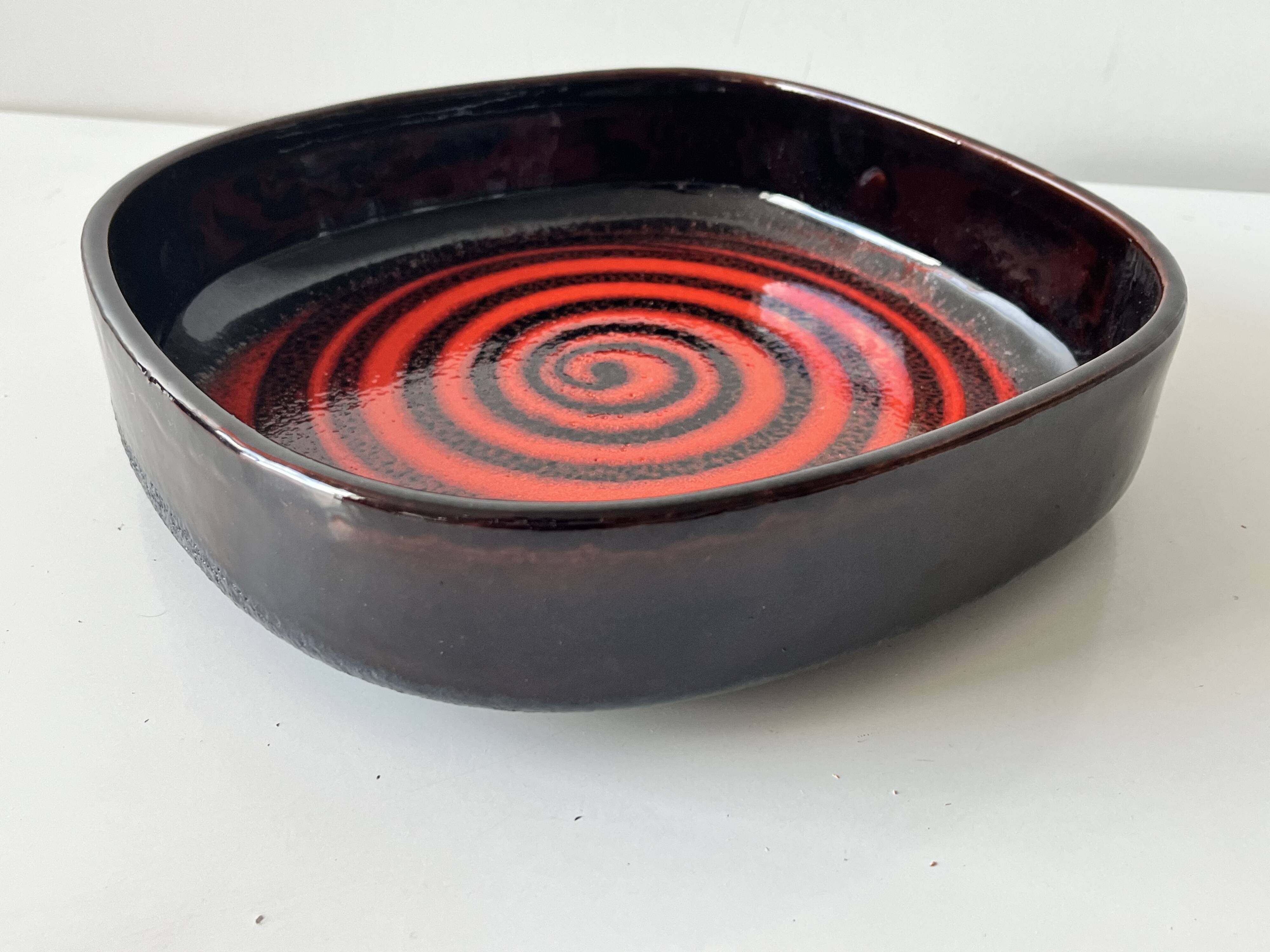 Large decorative ceramic catchall with red and black spiral pattern.