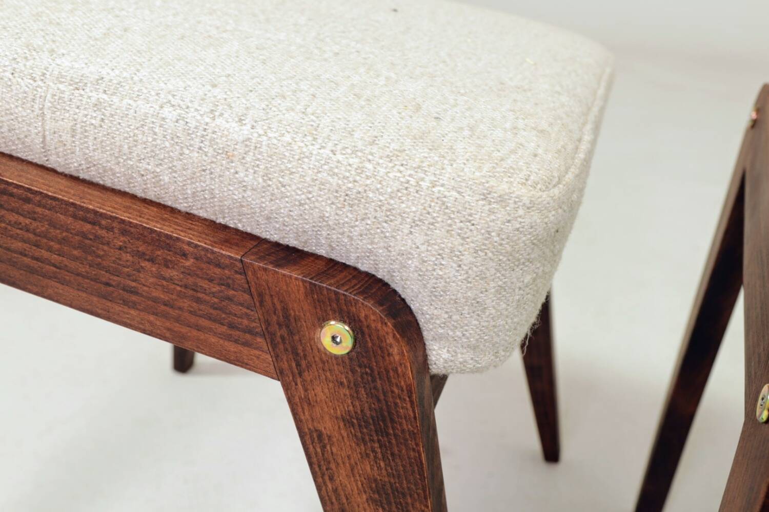 Pair of wooden stools with beige fabric.