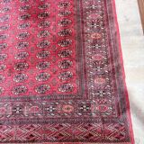Large red Bokhara-style oriental carpet 300x200 cm with gul patterns.