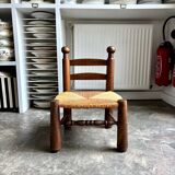 Brutalist low chair in dark wood and straw no. 1