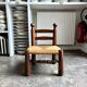 Low brutalist chair in dark wood and straw n°1