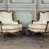 Pair of small Louis XV style wing chairs in carved walnut, Bosson stamp