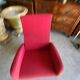 Old cinema chair with a red reclining seat.