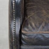 Black cow leather armchair in industrial style finished with decorative nails
