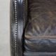 Black cow leather armchair in industrial style finished with decorative nails