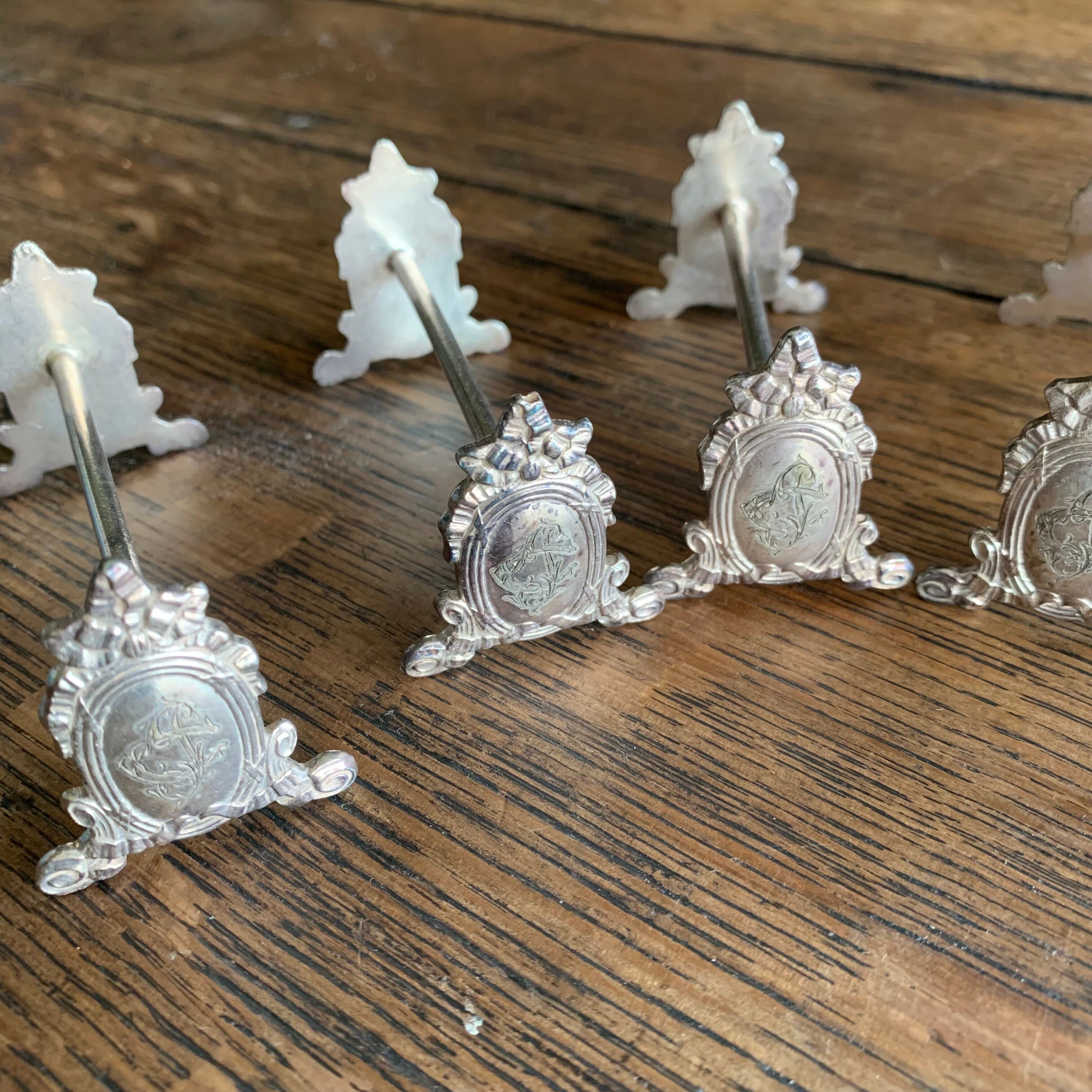 Series of 12 monogrammed silver metal knife holders