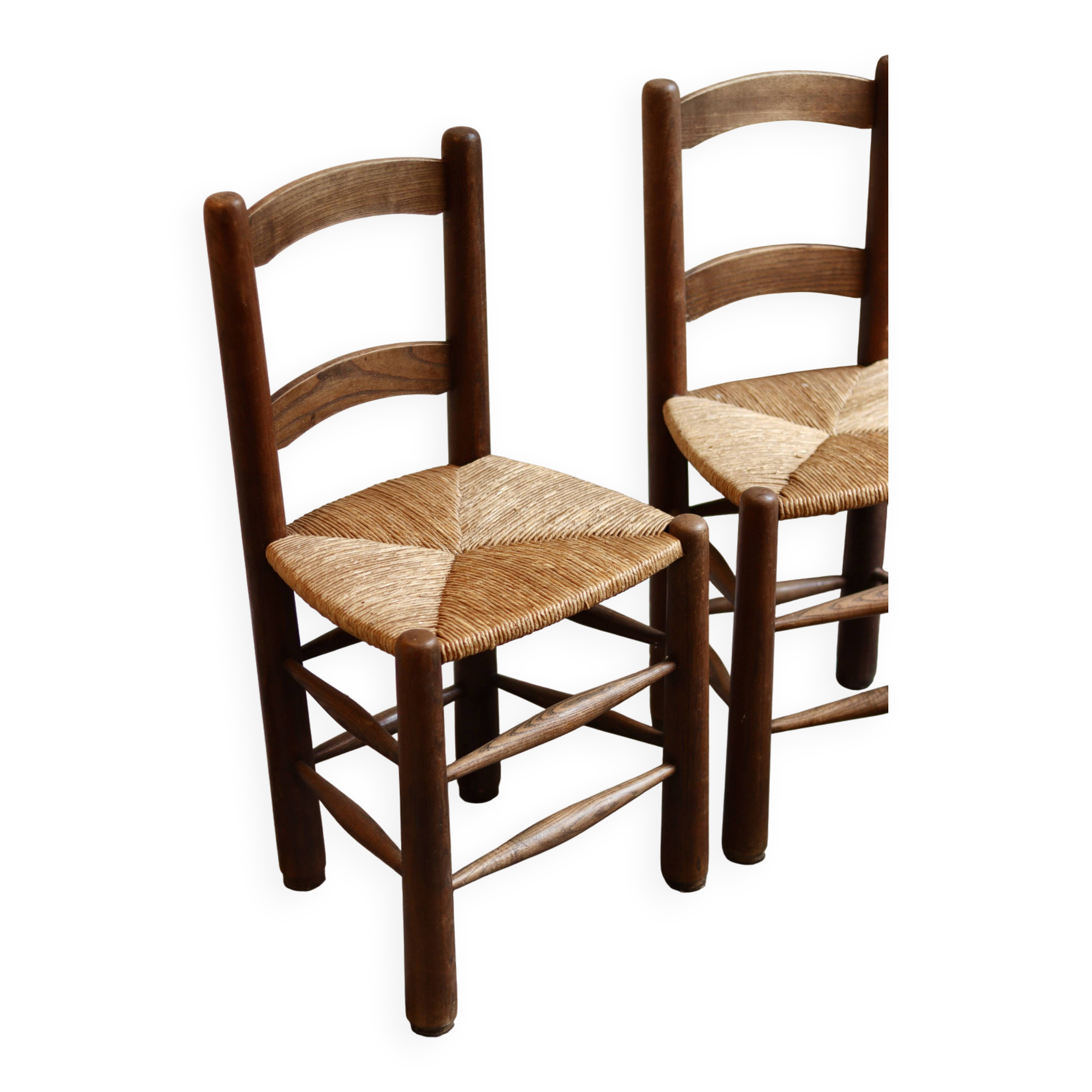 Pair of wooden chairs with woven straw seats.