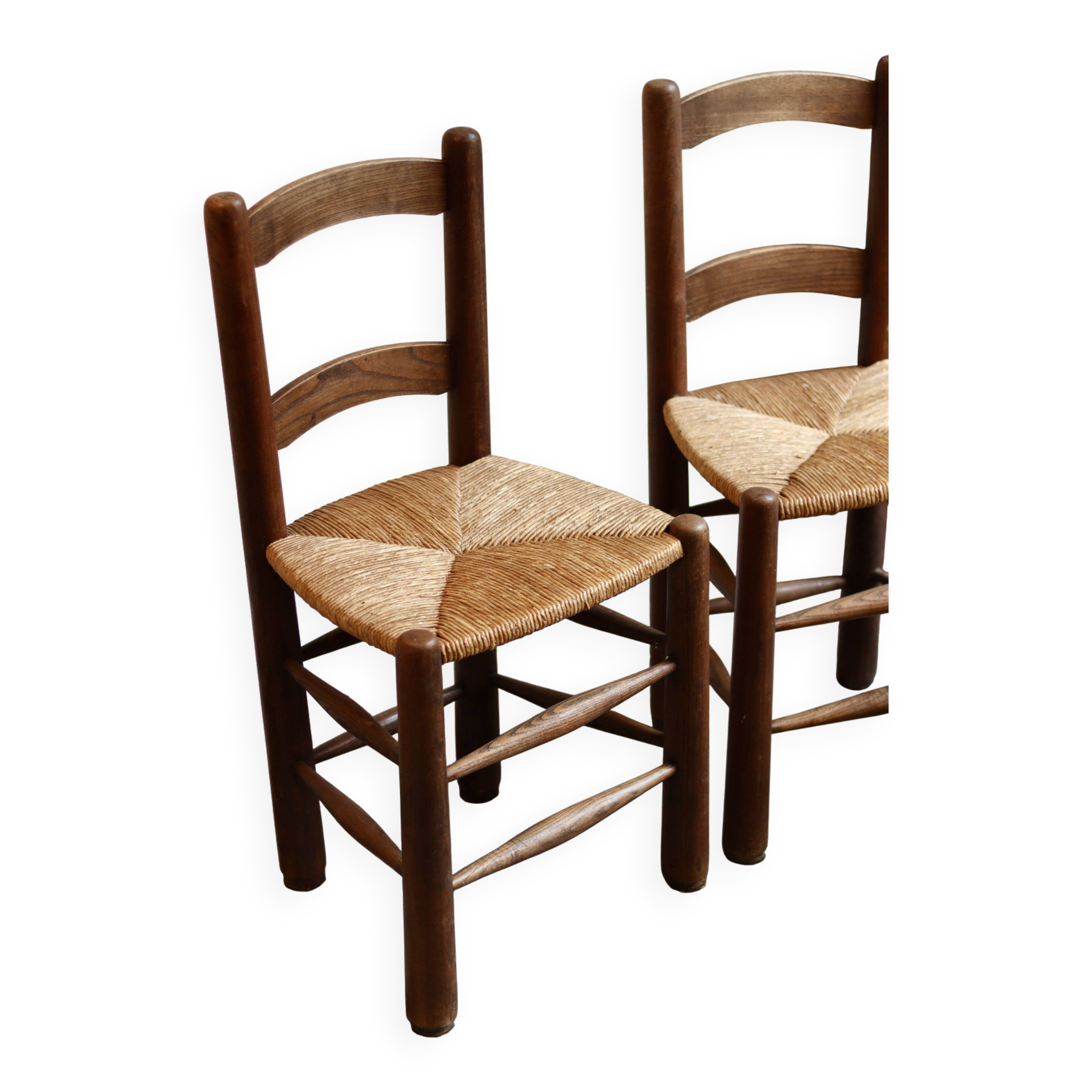 Pair of wooden chairs with woven straw seats.