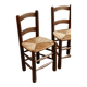 Pair of wooden chairs with woven straw seats.