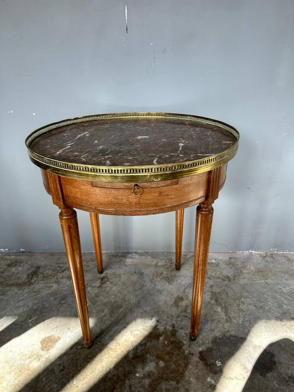 Hot water bottle table with a marble top and a brass gallery.