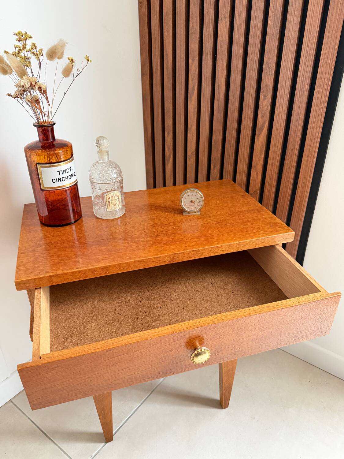 Vintage bedside table with tapered legs.