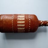 Vintage glass bottle covered with light brown leather and wicker