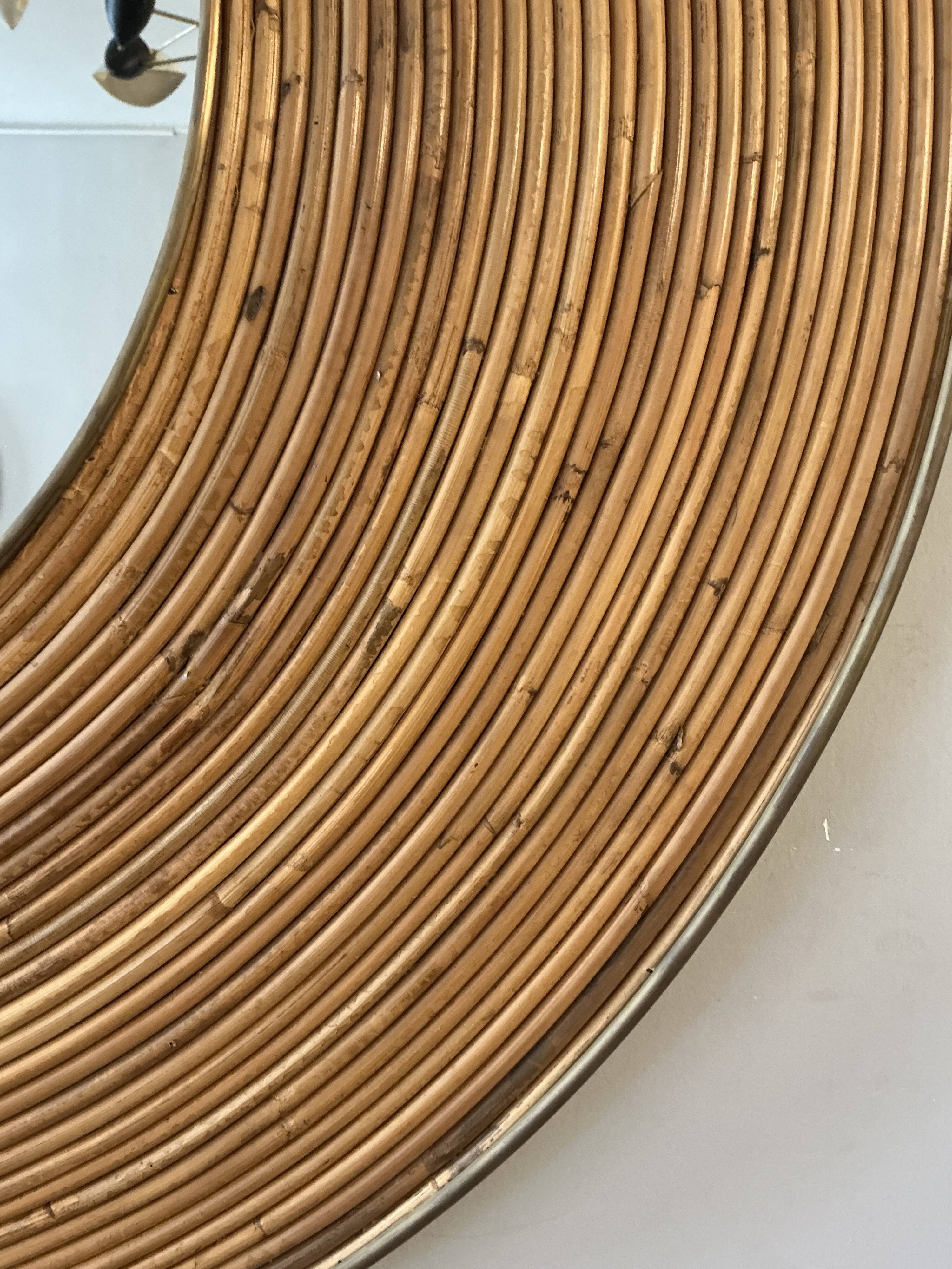 Large round mirror in rattan and brass