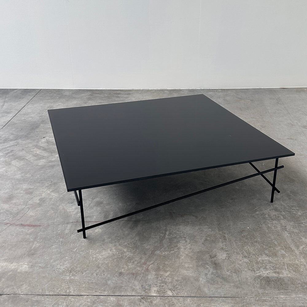 Minimalist black glass coffee table with industrial metal base