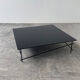 Minimalist black glass coffee table with industrial metal base