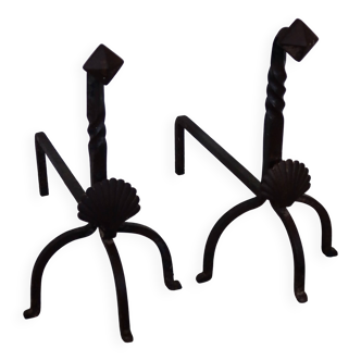 Vintage metal and cast iron fire dogs with shell motif.