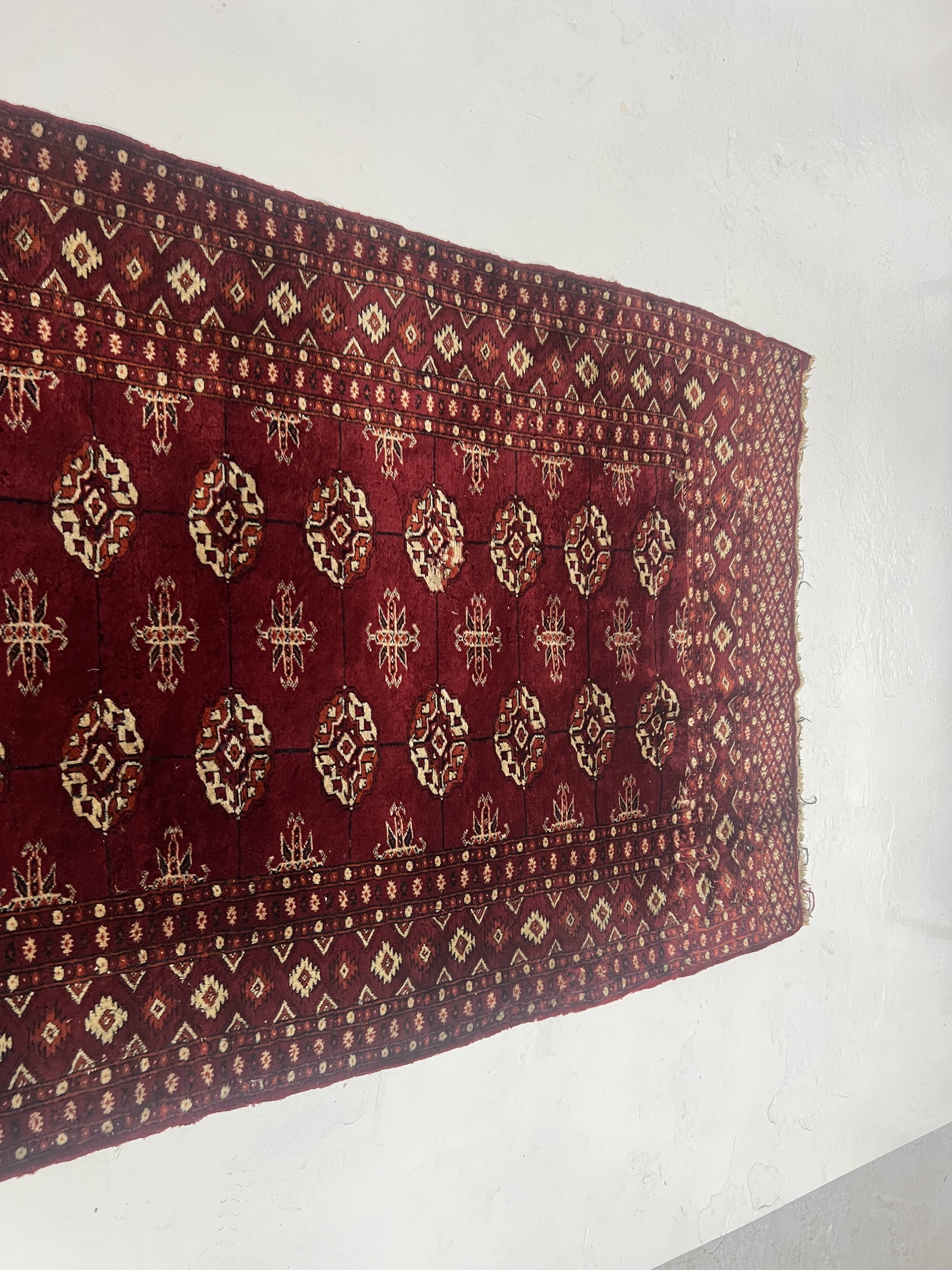 Antique wool rugs with designs on a red background, 20th century.
