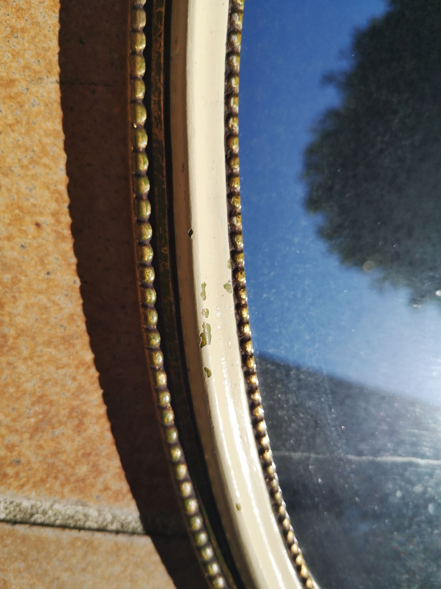 Ancien miroir ovale guilloché doré et peint