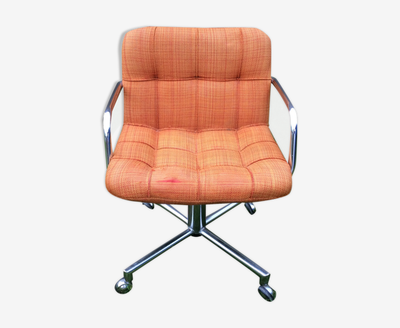 Fauteuil vintage à piétement en métal chromé pivotant et assises en tissu orange.