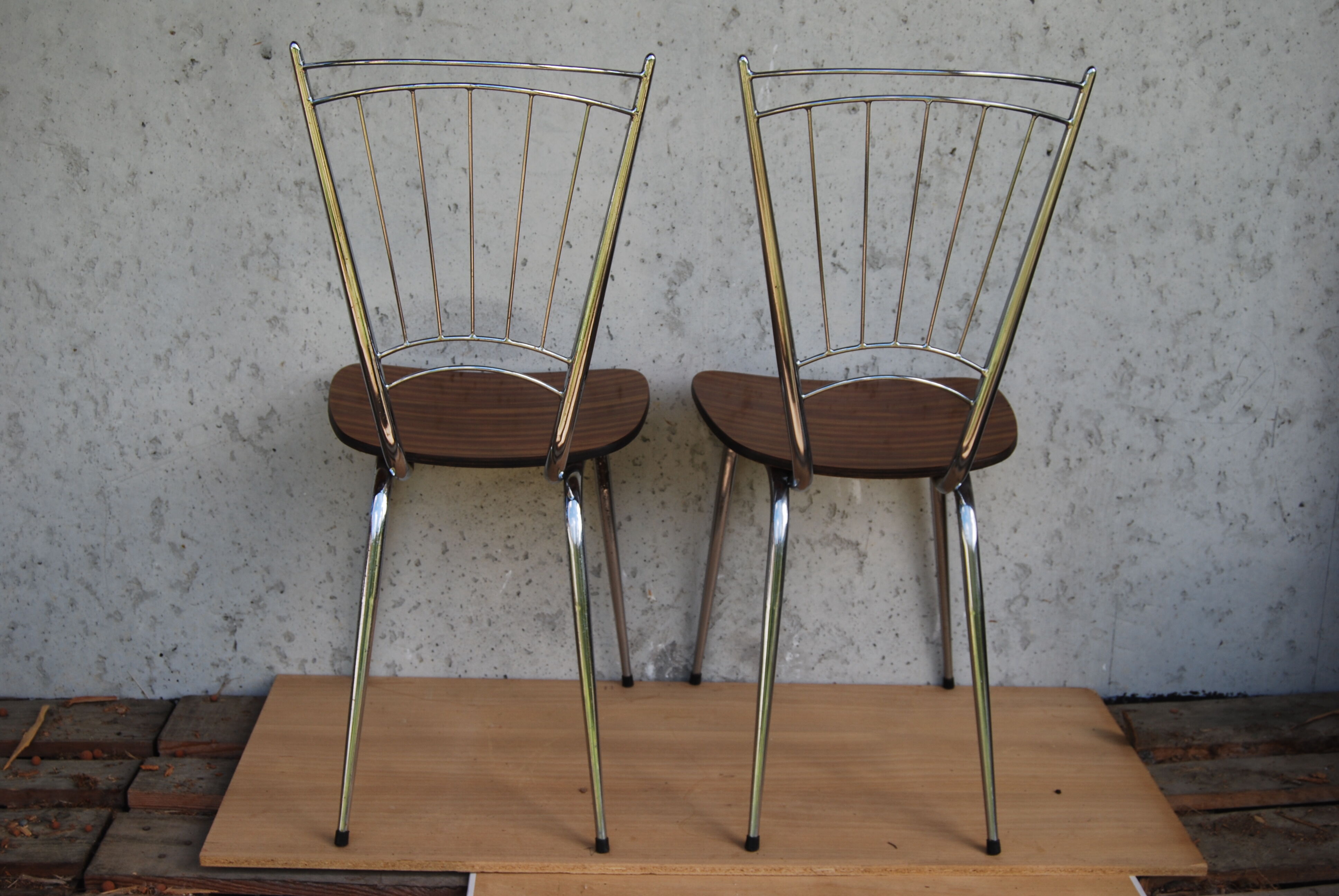 Pair of formica chairs with chrome metal backs in the shape of a lyre.