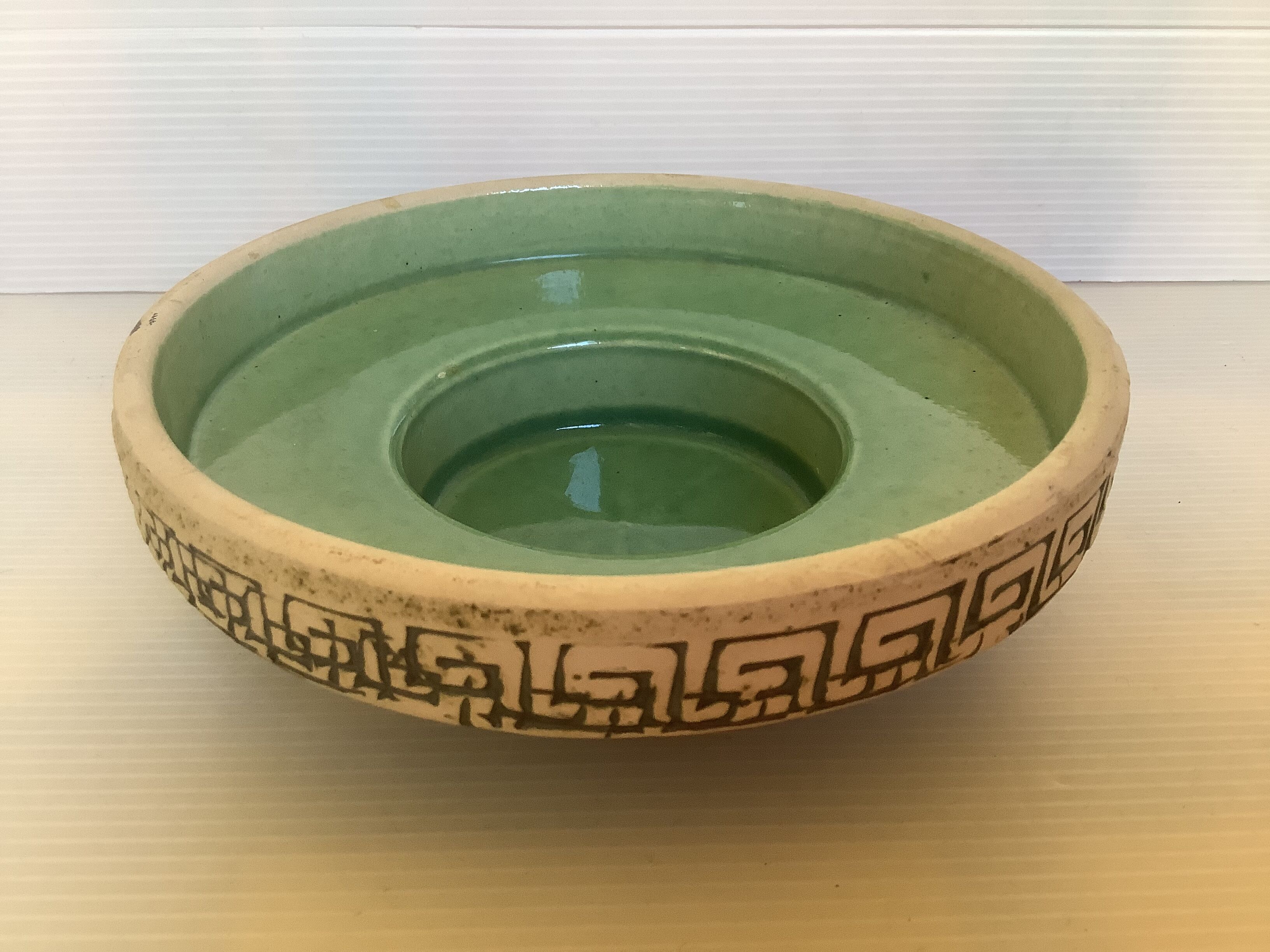 Green ceramic candle holder with a frieze