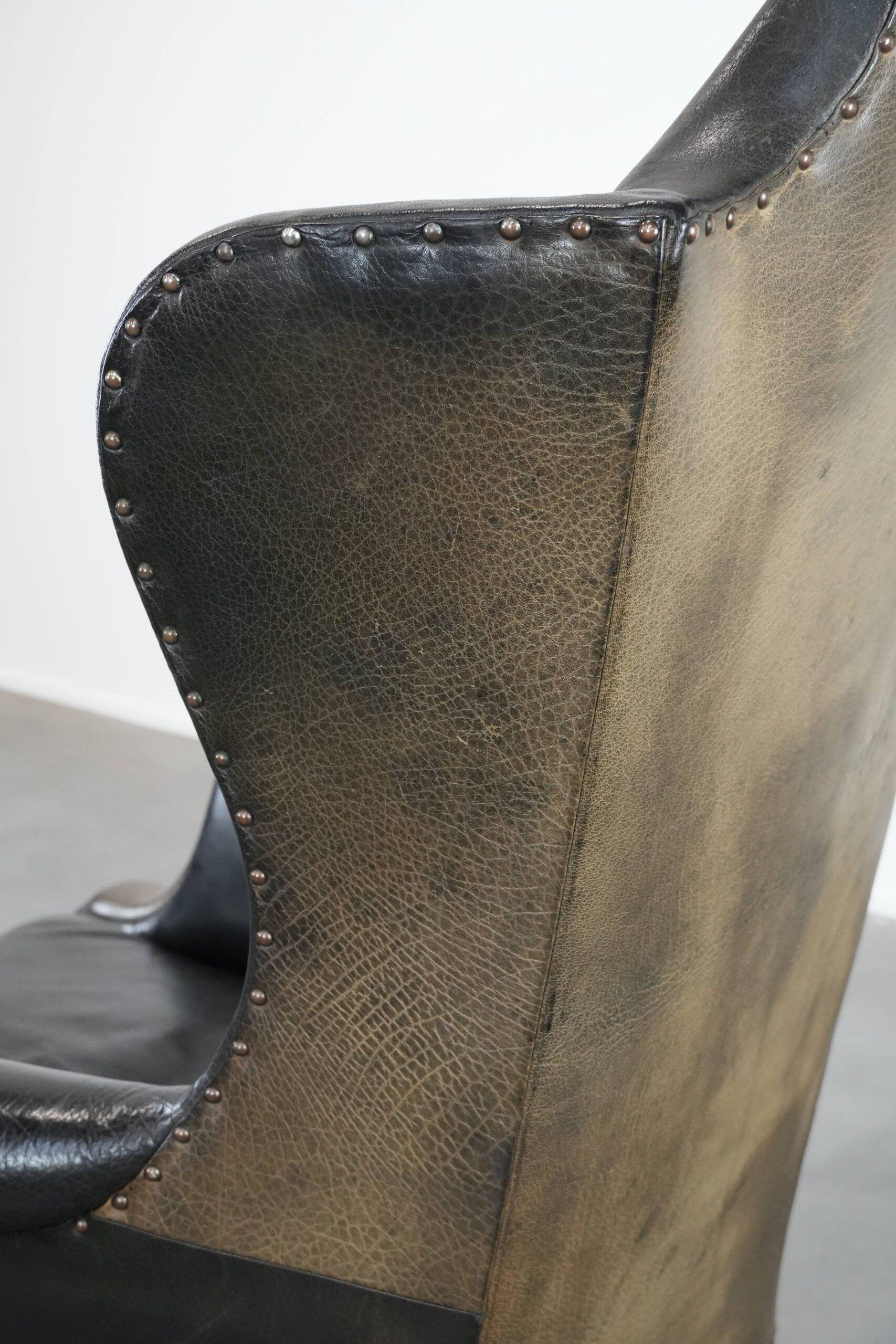 Antique black English cow leather wingback armchair from the 19th century