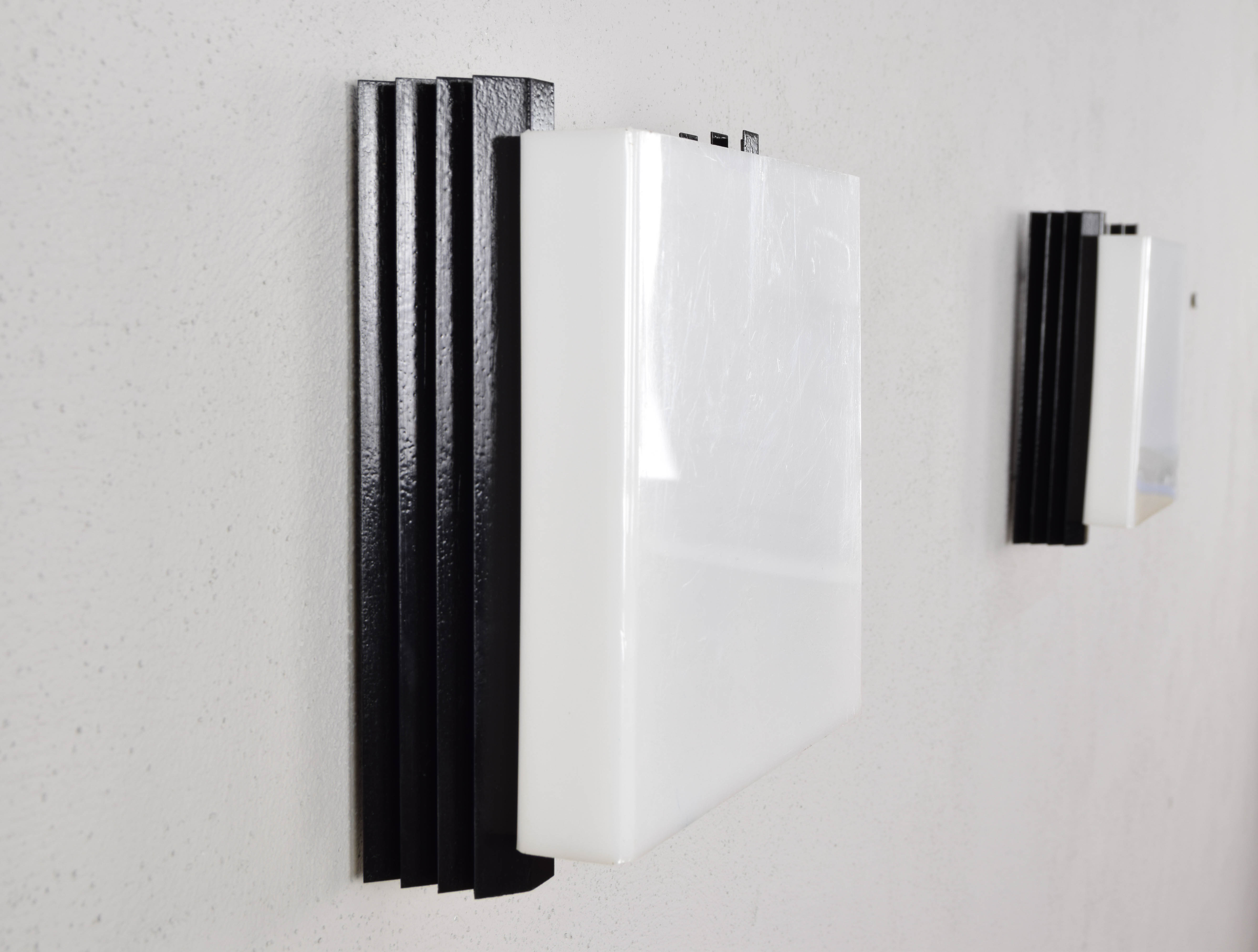 Mid-century modern sconces of black iron sheets and white lucite spain 1960s