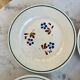 Set of 4 small flat plates with floral designs.