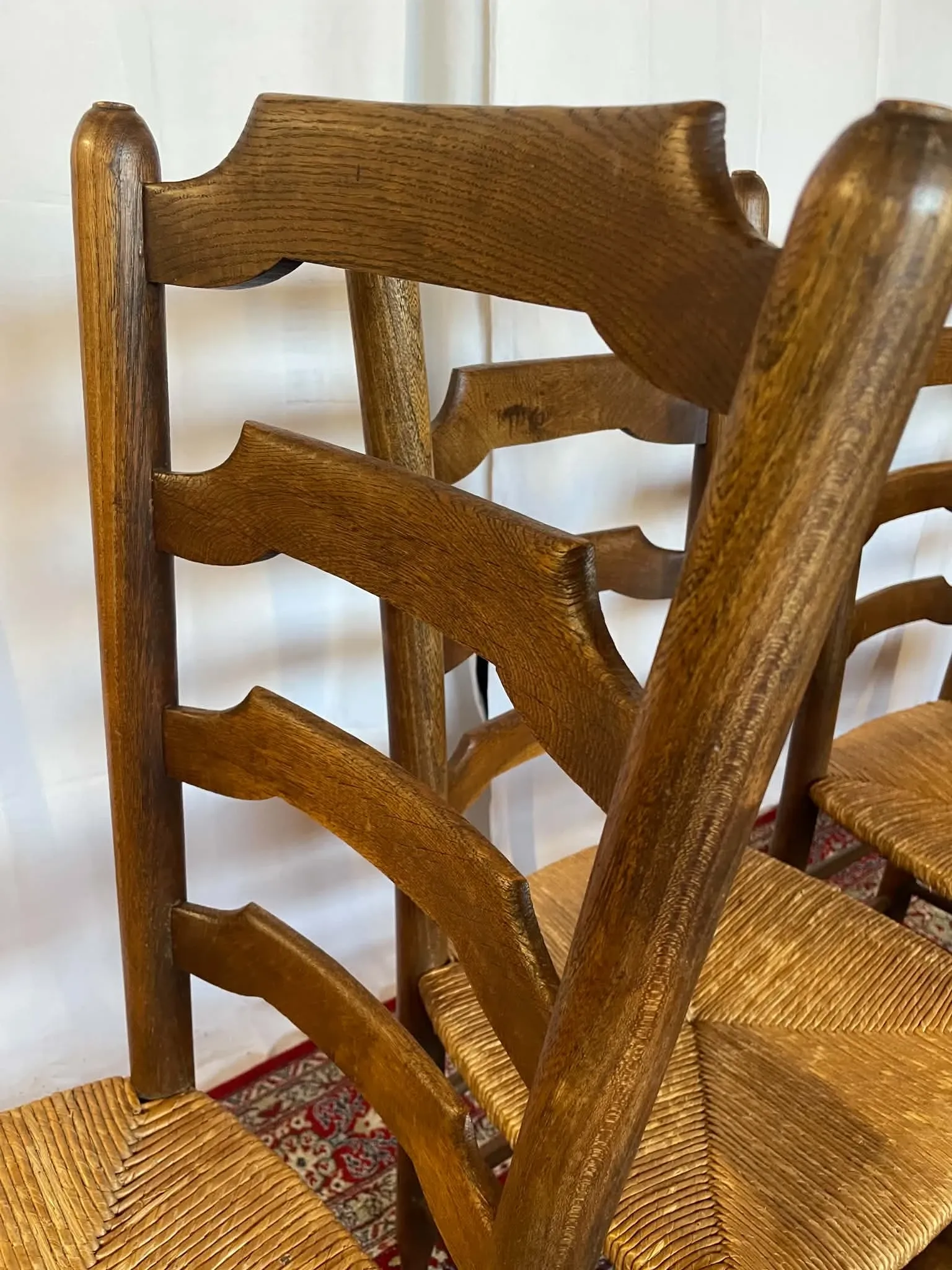 Set of 5 antique solid oak chairs with straw seats.