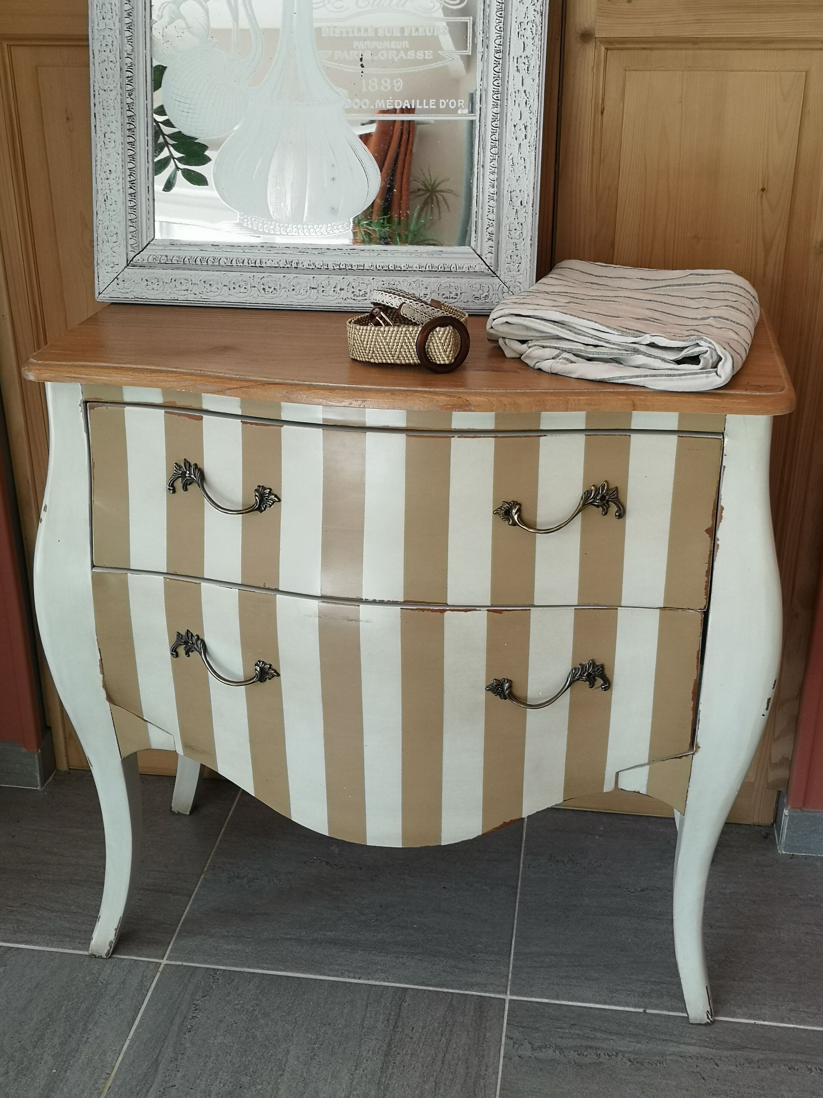 Curved commode with beige and white stripes.